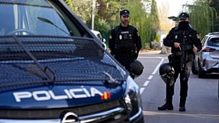 Police officers stand guard as other officers in yellow vests walk back at the cordoned off area next to the Ukrainian embassy in Madrid, Spain, Wednesday, Nov. 30, 2022.