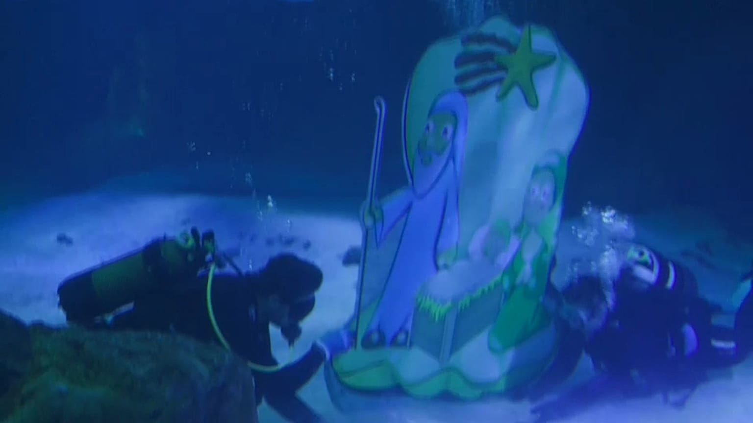 Divers setting up a nativity scene among fish and sharks in Madrid Zoo Aquarium.