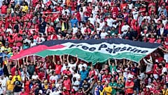 مشجعون يرفعون علمًا كتب عليه "فلسطين حرة" خلال مباراة كأس العالم بين تونس وأستراليا في الدوحة. 