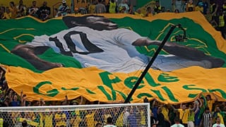 Football fans hold a giant Brazilian flag with a picture of Brazilian football legend Pele with a message "Pele, Get well soon" in Qatar, 2 December 2022