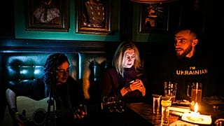 Un concert à la lueur d'une bougie, dans un bar de Lviv, plongé dans le noir, le 2 décembre 2022, Ukraine