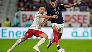 ماتي كاش البولندي، إلى اليسار، وكيليان مبابي الفرنسي يتنافسان على الكرة. ملعب الثمامة - الدوحة - قطر. 2022/12/04