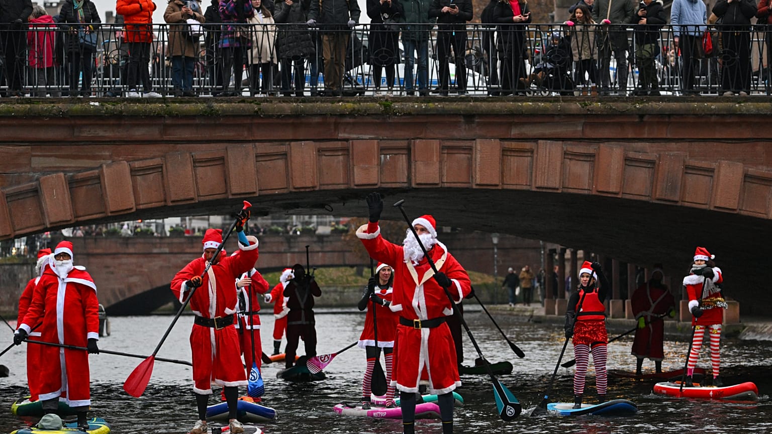 Des personnes déguisées en Père Noël en paddle à Strasbourg