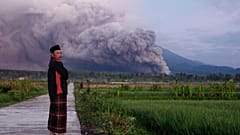 رجل ينظر إلى جبل سيميرو أثناء ثوران بركاني