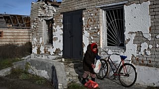 Une femme âgée reçoit de la nourriture à un point d'aide humanitaire mobile dans le village de Zaritchne, région de Donetsk, Ukraine, vendredi 2 décembre 2022.