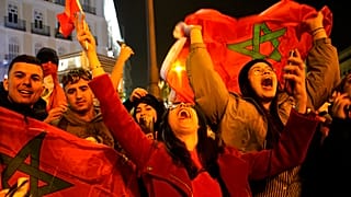Morocco's supporters celebrate after their team won the Qatar 2022 World Cup round 16 football match between Morocco and Spain, at the FIFA fan zone in Doha, 6/12/2022.