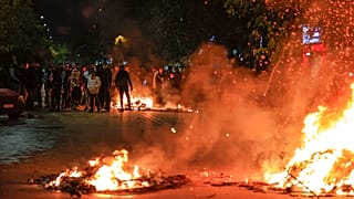 People blocking a main road set fire to rubbish bins outside the Ippokrateio General Hospital, in Greece's second largest city of Thessaloniki, on Monday, Dec 5, 2022. 