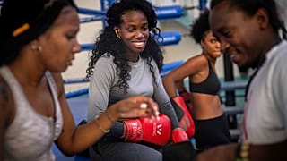 La boxeadora Legnis Cala, en el centro, habla con otras boxeadoras durante una sesión de entrenamiento en La Habana, Cuba.
