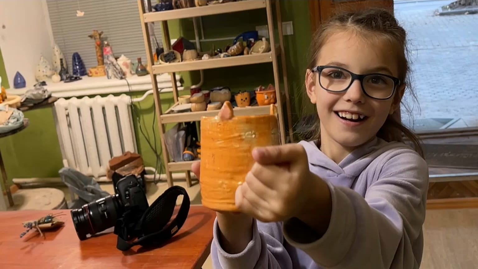 Una niña muestra la taza que ha hecho en el taller de cerámica de Mikolaiv