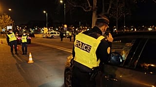 French police officers control a car near the National Assembly, as they enforce a curfew, in Paris, France, Tuesday Dec. 15, 2020.