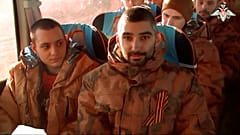 A group of Russian soldiers sit in a bus after being released in bilateral prisoner swap