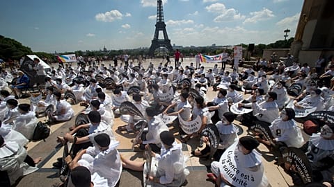 FILE: Demonstrators dressed as mime artists hold placards which read "no to the euthanasia of elderly people, solidarity is urgent", in Paris, June 2014