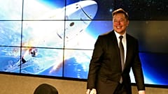 Musk a SpaceX Falcon 9 típusú rakétájának fotója előtt 