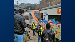Passengers and railway staff are seen at the scene of a train collision in Montcada i Reixac, Spain, Wednesday Dec. 7, 2022