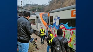 Passengers and railway staff are seen at the scene of a train collision in Montcada i Reixac, Spain, Wednesday Dec. 7, 2022