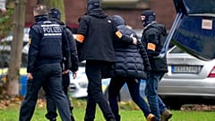 Un suspect escorté par des policiers à son arrivée au bureau du procureur fédéral à Karlsruhe, en Allemagne, mercredi 7 décembre 2022. 