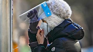 Una mujer se prepara para una prueba rutinaria de covid en un centro de Pekín.