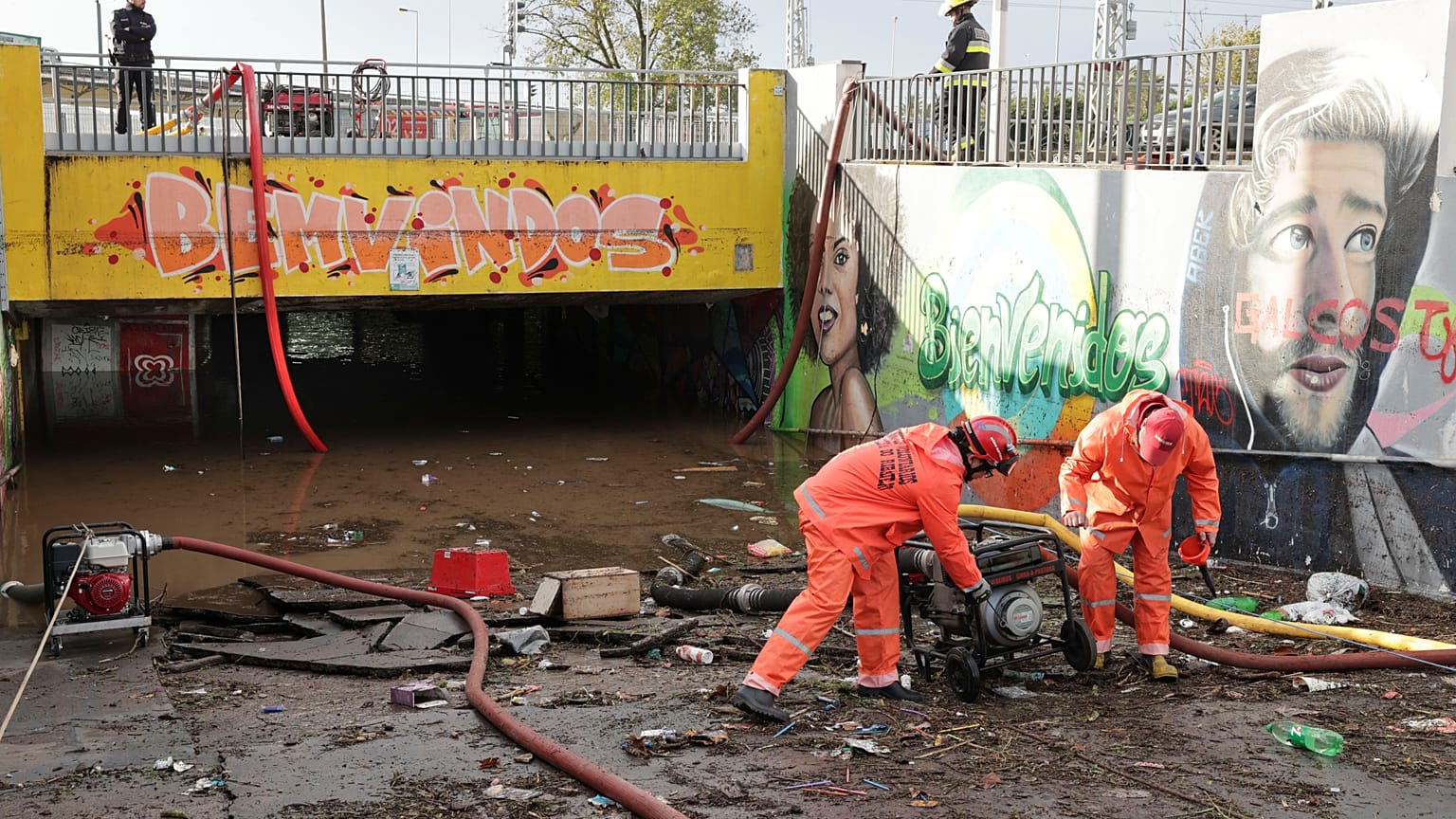 Elementos dos bombeiros usam bombas de escoamento de águas no acesso pedonal inferior à estação de comboios de Algés