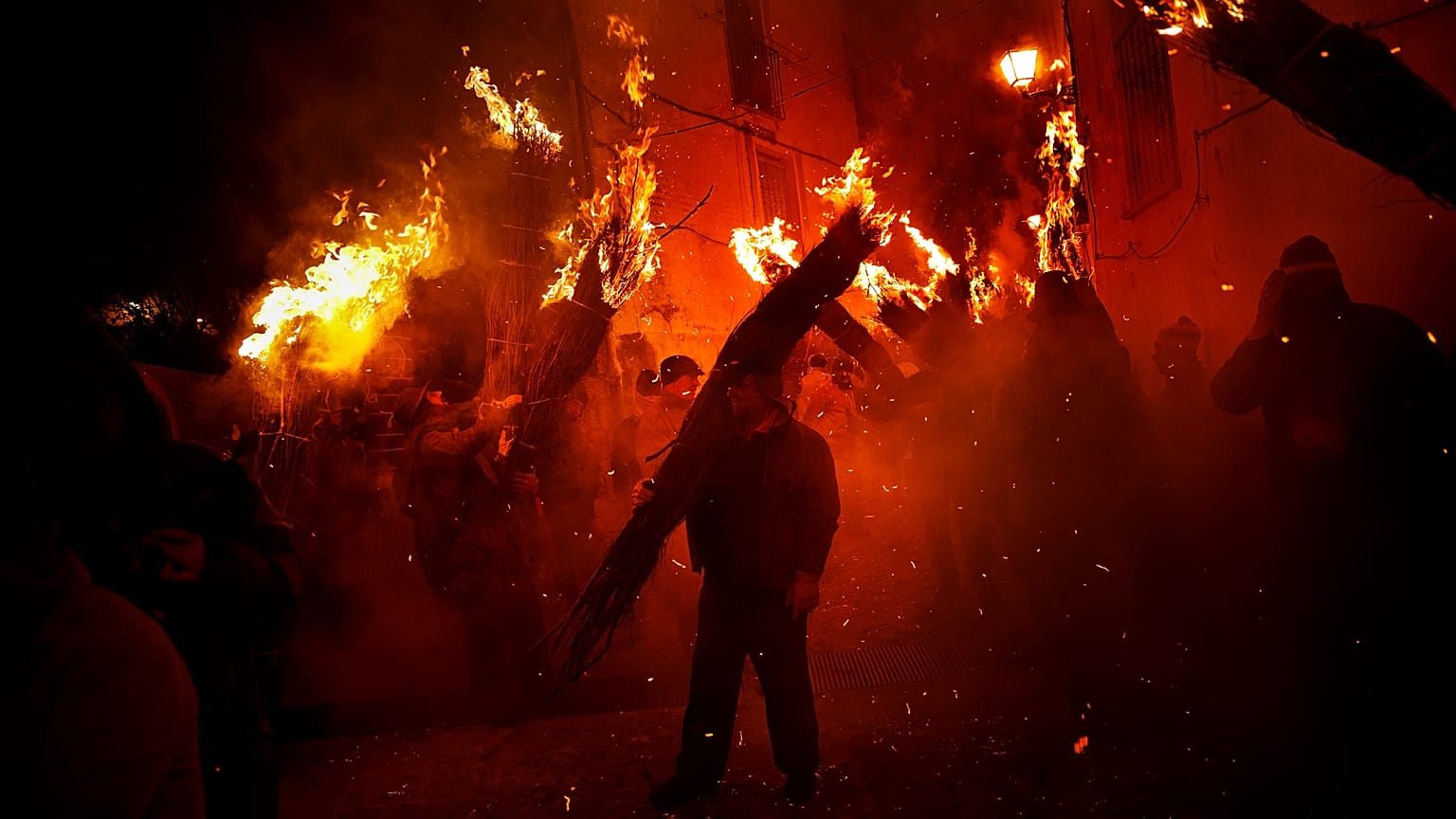 Villagers hold burning brooms during 'Los Escobazos' Festival in Jarandilla de la Vera, Spain