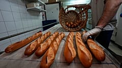 A Versailles baker empties his oven