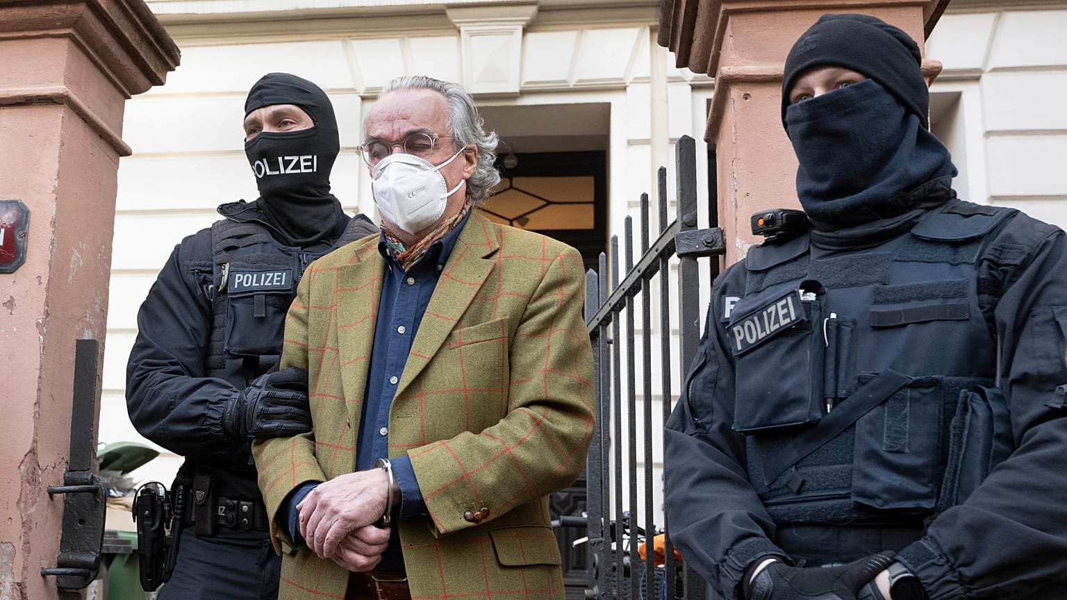 Masked police officers lead Heinrich XIII Prince Reuss to a police vehicle during a raid against so-called 'Reich citizens' in Frankfurt, Germany.