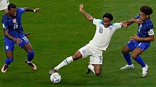 Raheem Sterling (középen) az amerikai Haji Wright (balra) és Tyler Adams között az Anglia-Egyesült Államok mérkőzésen az al-hori al-Bajt Stadionban 2022. november 25-én.