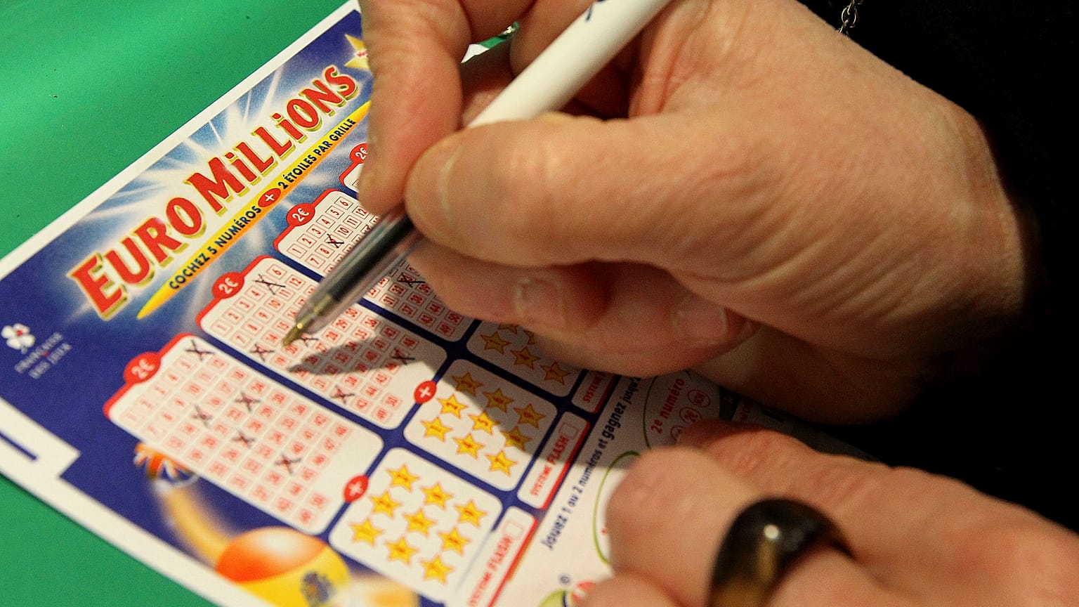 Egy játékos számokat jelöl meg egy EuroMillions szelvényen. 