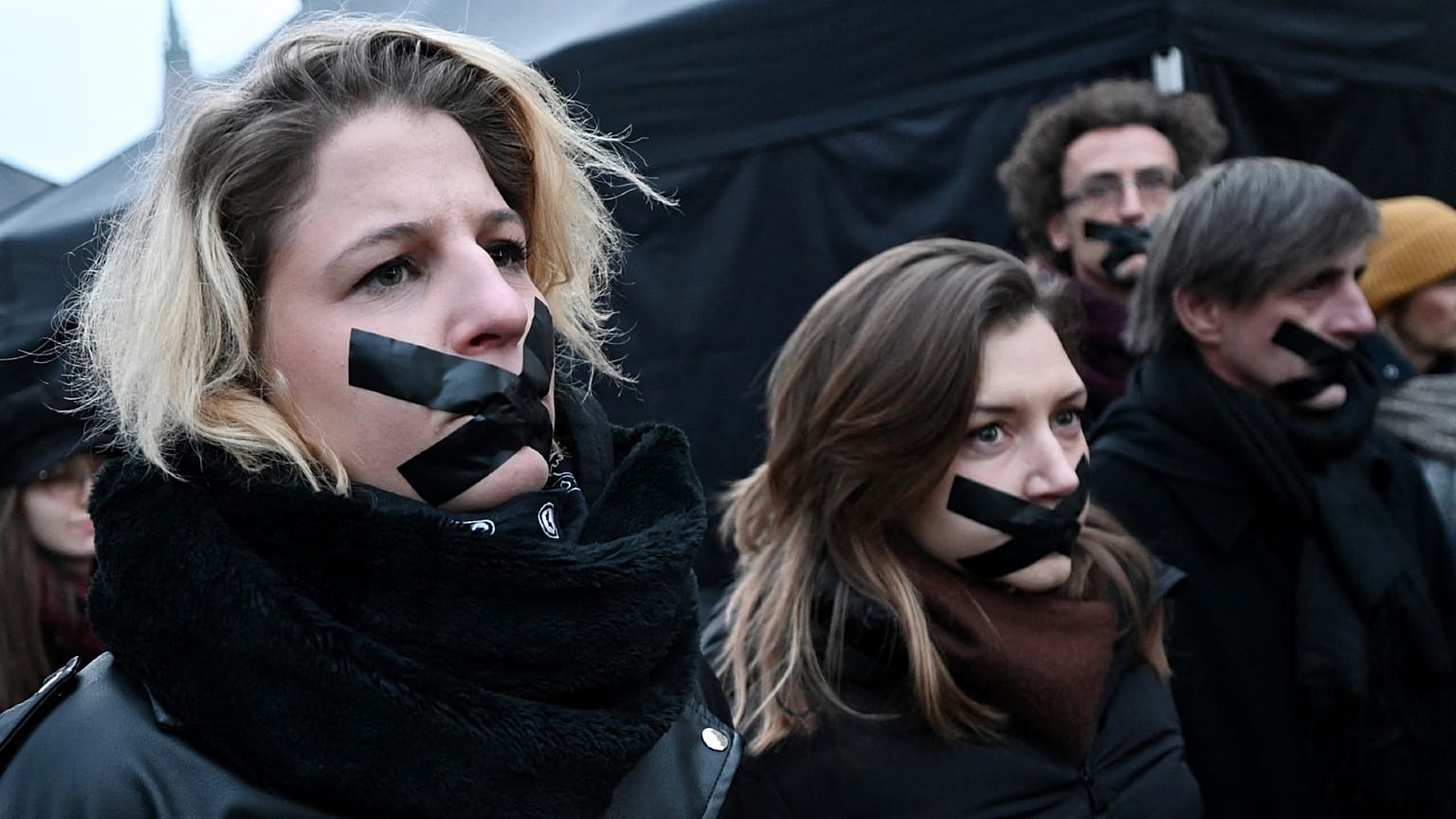 Participants stand with tape over their mouths during a demonstration of teachers, students and parents in Budapest