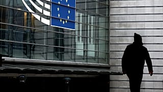 A man walks near the entrance of the European Parliament in Brussels on December 9, 2022.