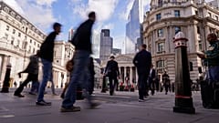 People walk outside the Bank of England, in the financial district known as The City, in London, Friday, Oct. 7, 2022.