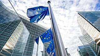 European Union flags flap in the wind at half-staff at EU headquarters in Brussels.