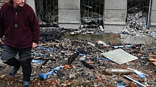Ein Mann geht an einer nicht explodierten Granate im ukrainischen Bachmut vorbei