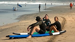 Endonezya'nın Bali Adası'nda bulunan Kuta Plajı kumsalında oturan yabancı turistler