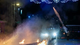 A policeman try to disperse protesters during a rally in the northern city of Thessaloniki.