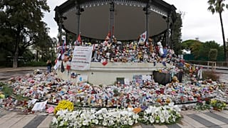 Flowers pile up at a makeshift memorial in a park on the Nice's famed Promenade des Anglais.