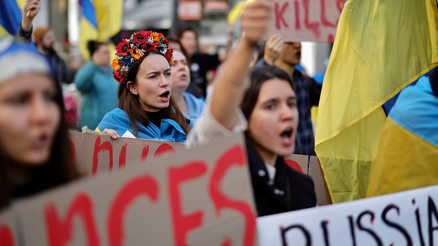 Protestors hold signs and chant during a demonstration outside of an EU summit in Brussels, Friday, Oct. 21, 2022.