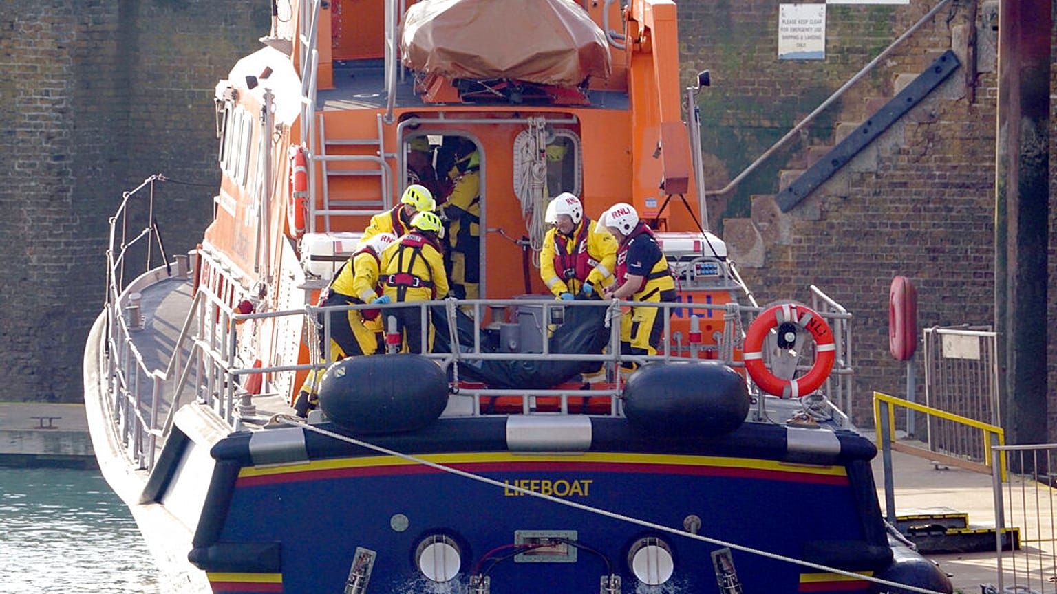 Miembros del bote salvavidas de Dover colocan una bolsa para cadáveres en una camilla después de una gran operación de búsqueda y rescate en el Canal de la Mancha, 14/12/2022