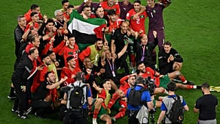 لاعبو منتخب المغرب يرفعون علم فلسطين خلال احتفالهم في ختام مباريات كأس العالم في قطر 2022 بدور الـ16 بين المغرب وإسبانيا على ملعب المدينة التعليمية، غرب الدوحة، 6 ديسمبر 2022.