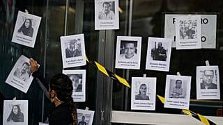 Un hombre coloca fotos de periodistas asesinados tras el asesinato del periodista Fredid Román durante una vigilia en Ciudad de México, el 24 de agosto de 2022.
