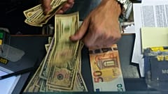 Eine Kassiererin wechselt an einer Wechselstube in Rom einen 50-Euro-Schein in US-Dollar