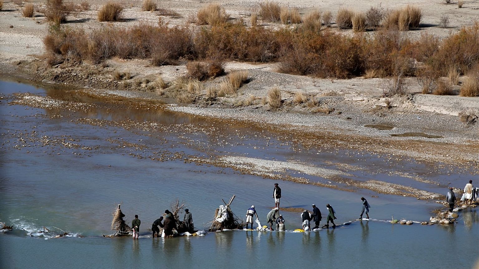  Afghans try to repair a dam on a river as seen from the British forces forward operating base Sterga II at Helmand province in southern Afghanistan, Dec. 16, 2013.