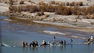  Afghans try to repair a dam on a river as seen from the British forces forward operating base Sterga II at Helmand province in southern Afghanistan, Dec. 16, 2013.