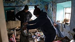 FILE - A family look through their possessions at their house which was occupied by Russian forces, in recently liberated village of Pravdyne, Kherson region, Ukraine, Tuesday
