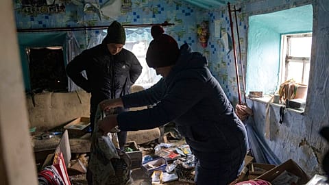 FILE - A family look through their possessions at their house which was occupied by Russian forces, in recently liberated village of Pravdyne, Kherson region, Ukraine, Tuesday