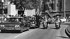 In this Nov. 22, 1963, file photo, President Kennedy's hand reaches toward his head within seconds of being shot as first lady Jacqueline Kennedy holds his forearm.
