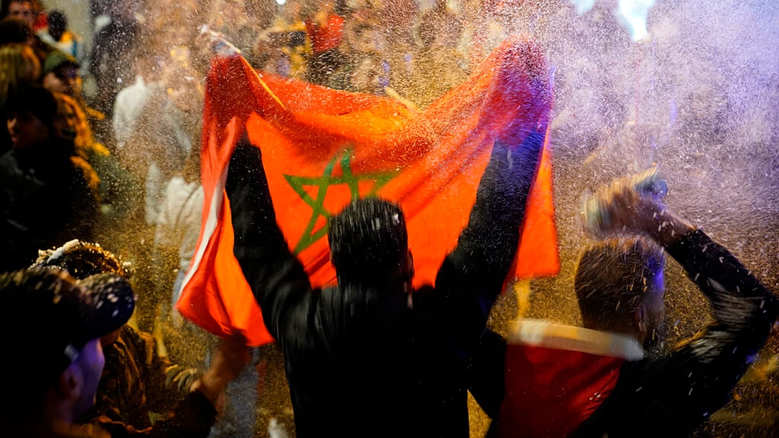 A man waves a Moroccan flag after the team's World Cup win over Spain