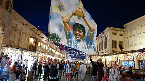 A fan of Argentina waves a flag with the image of late Argentinean soccer star Diego Maradona in Souq Waqif market in Doha, Qatar, Thursday, Dec. 15, 2022
