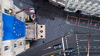 Workers attach an EU flag on a building in a main street in Sarajevo, 16 December 2022