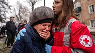 A woman cries in front of the building which was destroyed by a Russian attack in Kryvyi Rih, Ukraine, Friday, Dec. 16, 2022.