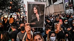 متظاهرة إيرانية تحمل صورة مهسا أميني